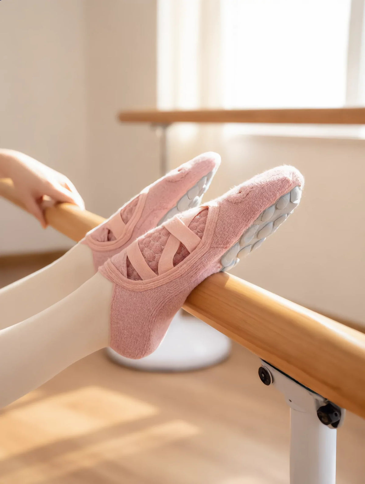 Chaussettes grip Ancrée rose poudre sur une barre de danse, semelle à picots visible