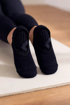 Chaussettes grip Ancrée noires sur un tapis de Pilates